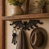 Gothic cast iron bat wall hook rack in a rustic entryway